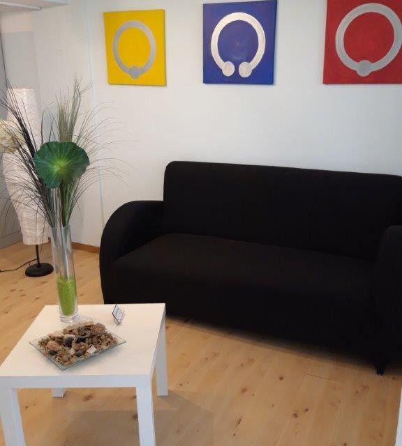 SIOUXSIE - PIERCING + LIFESTYLE – Wartebereich mit schwarzer Couch und Beistelltisch