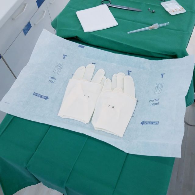 SIOUXSIE - PIERCING + LIFESTYLE – Sterile Einweghandschuhe auf einem Operationstisch